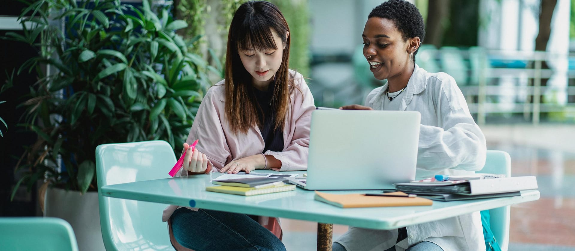 An Asian American female student and A Black American female student studying together